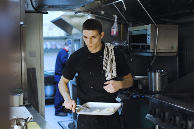 Image of Tyler, a Greene King chef and ex-offender, working in a kitchen